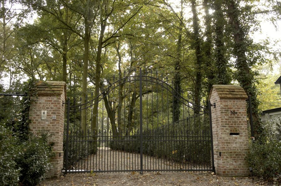 Poort van smeedwerk met oprijlaan