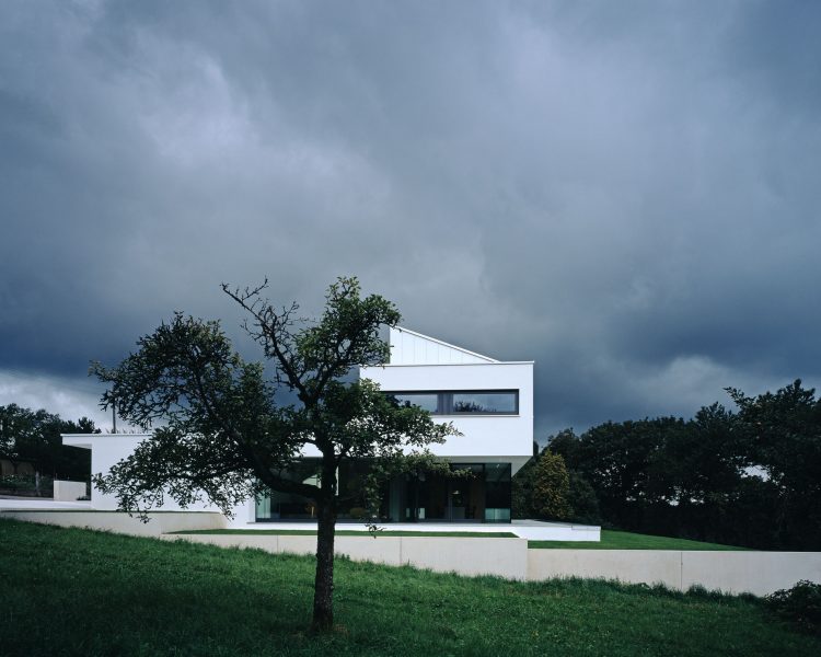 Donkere wolken laten de witte villa stralen